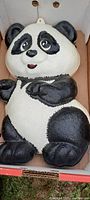 Large thin plastic panda bear in black and white with hanging loop, cracked edges visible.