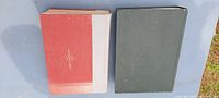 Top view of the two antique hardcover books showing covers; one red and white, the other dark green.