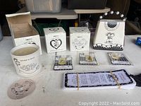 Photo of the lot showing the Girls Night Out bank, boxed candle votives, necklaces on cards, and a bundle of bookmarks, all on a table with white surface.