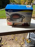 Photo of the front of the box showing the Rival Electric Fondue Pot with a fondue fork and fondue serving image.