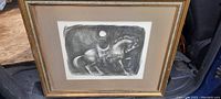 Full framed woodblock print showing horse and rider under a large moon with textured black and white shading.