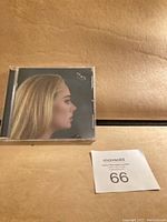 Closed front cover of Adele 30 CD album showing profile image of Adele's face with blonde hair.