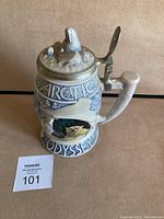 Front and side view of the Avon Arctic Odyssey collectable beer stein showing the hinged pewter lid with icy mountain motif, detailed bear sculpture, and Arctic-themed decorations with text 'Arctic Odyssey'.
