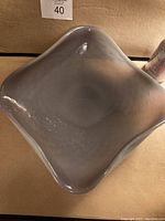 Top view of the square purple lilac glass bowl showing smooth, curved edges and semi-translucent coloring.