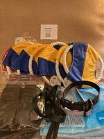 Four yellow and blue fabric dog toys with white rope handles, two dog collars (one black, one green), one black leash.