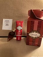 Photo showing 30 ml Killer Queen perfume spray bottle, 75 ml Killer Queen shower gel tube, and the matching glittery red box with logo.