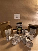 Lot of 10 LED GU10 bulbs, some in original packaging, displayed on beige background.