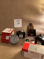 Photo showing all items arranged: timer switch box, analog pressure gauge, two Siemens breaker switches, thermostat component