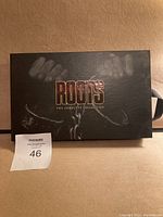 Box set cover with 'ROOTS The Complete Collection' title in gold and a shackle visual on black background.