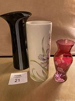 Full view of three vases: contemporary black vase, Sadler floral vase, pink crystal vase.