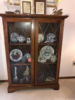 Front view of cabinet showing two glass-panel doors and crown molding.