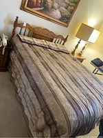 Full view of queen bed with wooden headboard and patterned bedding set on bed