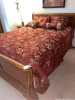 Overall view of queen sleigh bed with red and gold floral bedding set