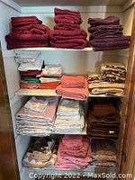 Overview of all towel stacks showing variety in colors and patterns including deep red, white, pink, brown, beige, and blue towels.