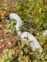 Close-up of white heron sculpture in garden foliage
