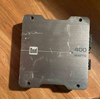 Top view of a rectangular metal Dual audio amplifier showing '400 WATTS' marking and scratches.