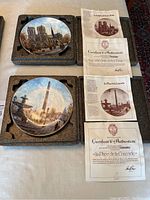 Photo showing collector plates for Notre-Dame Cathedral and Place de la Concorde with their certificates of authenticity and protective boxes.