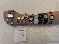 Nine ladies quartz fashion watches displayed on a model's arm to show the variety of styles including chain bracelets, expansion bands, and metal bracelets.