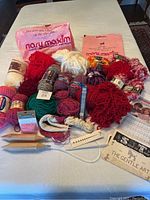 Full lot overview showing all yarn skeins, needle sets, beads, and patterns arranged on a table