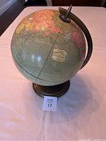 Full view of the multicoloured vintage Cram's Imperial globe on metal base showing general shape, size, and style.