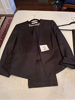 Black Tahari pinstriped suit jacket with matching pants laid out showing fabric texture, style, and size tag.