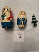 Frontal view of the Santa Claus doll, Mrs Claus doll, and the small Christmas tree figure, showing their painted details and sizes.