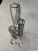 Full view of the jewelry set displayed on the metal stand on a white patterned tablecloth, showing all items included.