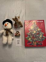 Photo of the full lot including Snowflake the Snowman plush, Kanga Gund plush, Christmas snow globe, and Springbok Christmas tree puzzle box