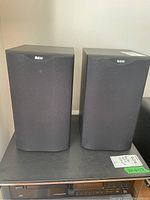 Front view of both speakers on shelf