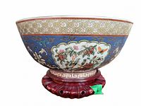 Front profile of cloisonne bowl on carved wood stand against white background