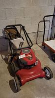 Full view of red Craftsman gas lawn mower with black and white fabric grass collection bag attached, showing wheels and handle.