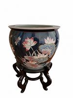 Front view of navy blue planter on carved wood stand