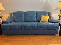 Front view of full sofa with accent pillows and floor lamps.