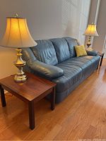 Overview of both side tables placed beside a sofa with lamps, showing scale and finish.