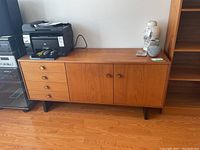 Full frontal view showing left drawers, right cupboard doors and black legs