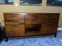 Front view of wooden file cabinet showing three upper drawers, two lower drawers, and open shelf space.