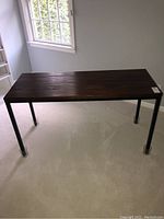 Full view of dark wood top sofa table with black metal frame and removable legs