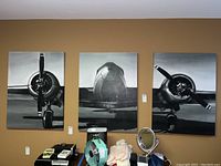 Three mounted airplane art pieces in black and white, each measuring around 40x30 inches displayed on a wall.