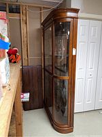 Front quarter view showing curved glass panels and wood frame