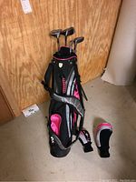 Full set of Walter Hagen kids golf clubs in black and pink golf bag, standing upright, shoulder strap visible