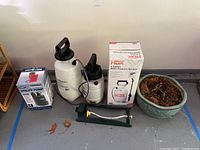 Full lot showing 3 sprayers, green oscillating sprinkler, ceramic decorative pot, and boxed utility pump