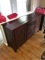 Front-left angle view showing three center drawers flanked by two cabinet doors.