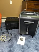 HP LaserJet Pro 200 Color Printer M251nw and Fellowes Powershred 79Ci shredder together on carpeted floor with user manual in front
