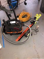 Overview showing Ryobi hedge trimmer, Tacklife wet/dry vacuum, extension cords