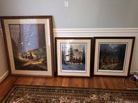 Three framed western wall art prints displayed against a wall, one larger print on left, two smaller prints on right, showing overall lot contents.