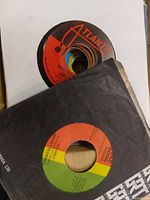 Close-up of two vintage 45 RPM vinyl records from the lot, showing Atlantic and Gold Crown labels partially visible.