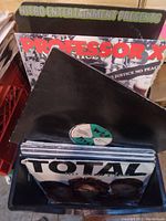 Photo showing vinyl records in crate including albums by Professor X and Total.