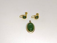 Pair of 14k yellow gold screw-back earrings with round green cabochon stones and matching 14k yellow gold pendant with larger oval green cabochon stone.