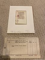 Full view of the mounted vellum leaf with accompanying invoice sheet visible beneath.