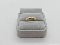 Ring displayed upright on a gray velvet ring box